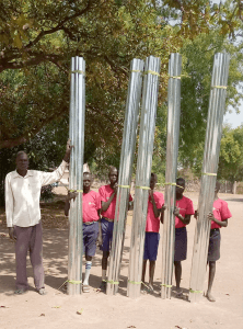 children with large roles of metal roofing material